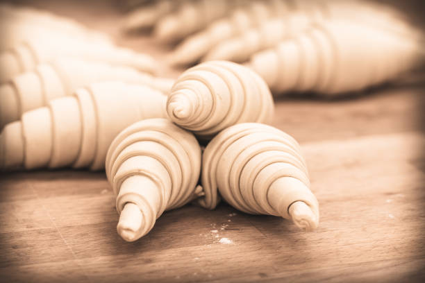 Raw croissants on a baking tray, prepared for baking