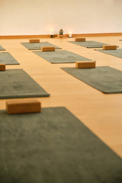 A yoga studio with a lot of mats and blocks. No people.