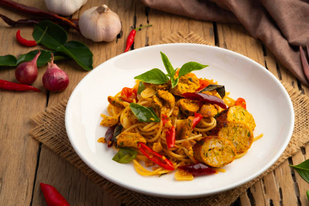 istock Stir fried Spaghetti with Northern Thai spicy sausage.pasta with chilli garlic and basil leaves in white plate. 2151431356