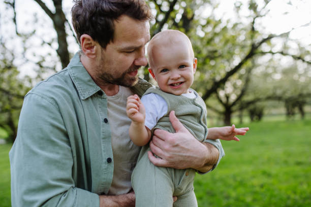 istock Father holding little baby, playing, having fun during warm spring day. Father's day concept. 2151432474