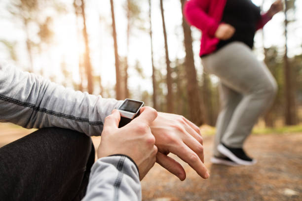 istock Overweight woman running down the stairs, personal trainer checking, timing her performance. Exercising outdoors for people with obesity, support from friend, fitness coach. 2151435384