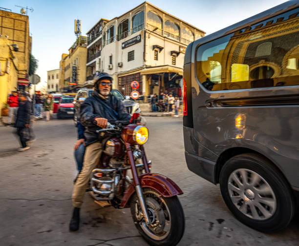 Motorcyclist navigating traffic near Bab Bou Jeloud in Fez.
