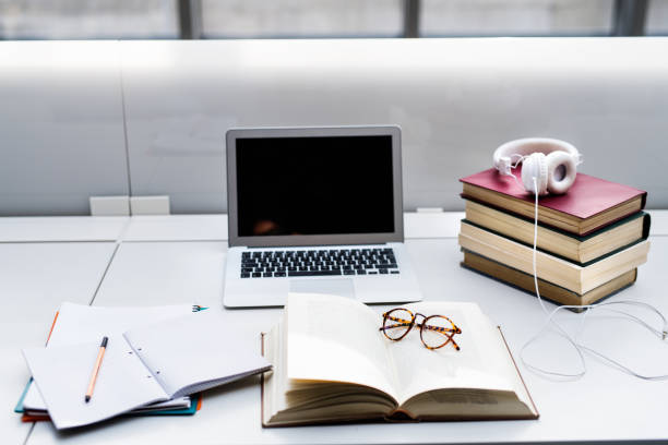 Creating effective, ideal study space. Laptop, textbooks, notes and music for univesity student.