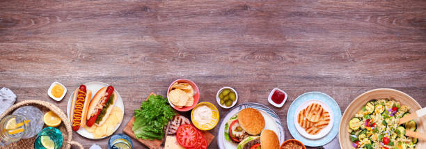 istock Summer BBQ or picnic bottom border  over a dark wood banner background 2151445745