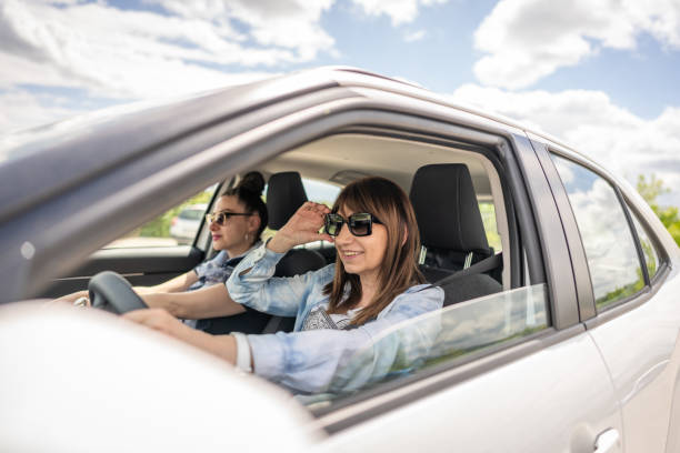 istock Female friends going on a road trip in a car. 2151451831