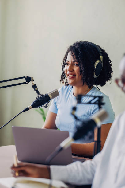 istock Smiling Woman Recording Podcast Interview in Studio 2151451931