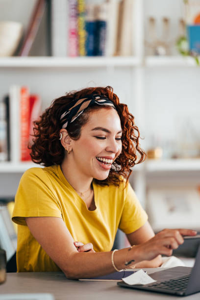 istock Young Woman Smiling While Working on Laptop at Home 2151453343