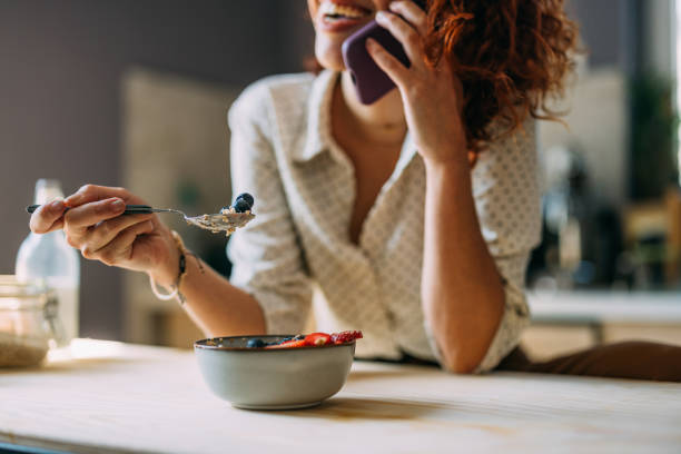 Happy Woman Enjoying Healthy Breakfast While on Phone