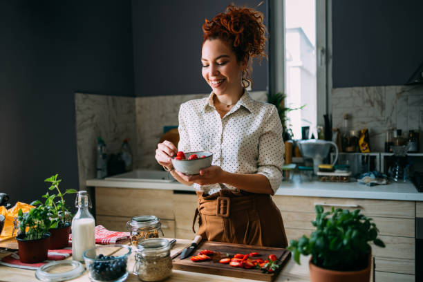 istock Happy Woman Cooking with Fresh Ingredients in Modern Kitchen 2151453416