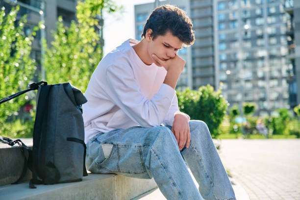 istock Upset sad unhappy young male sitting outdoor on steps 2151457006