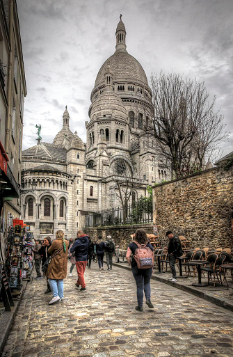 Tourist walking towards Sacre Coeur in beautiful street of Montmartre Paris, France