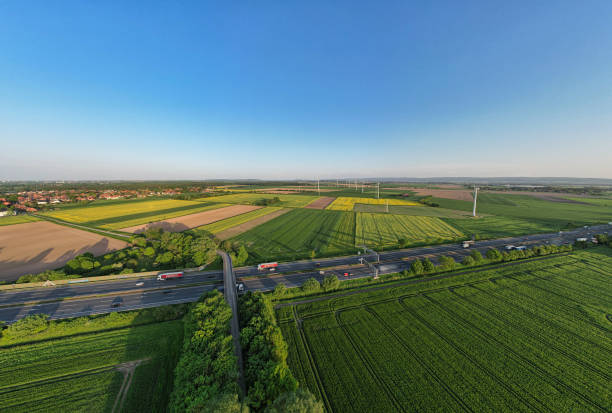 istock Highway cutting through lush green fields in a natural landscape under blue sky panorama drone view Hanover Wunstorf Kolenfeld Germany 2151465190