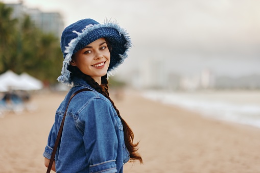 Happiness Amongst Nature: A Pretty Young Lady, Smiling and Stylishly Posed in a White Hat, Enjoying the Autumn Breeze on a Sunny Day in the City