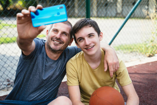istock Father and son taking a selfie outdoors whilst playing basketball. 2151472522