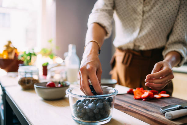 istock Woman Preparing Fresh Berries and Vegetables in Modern Kitchen 2151490573