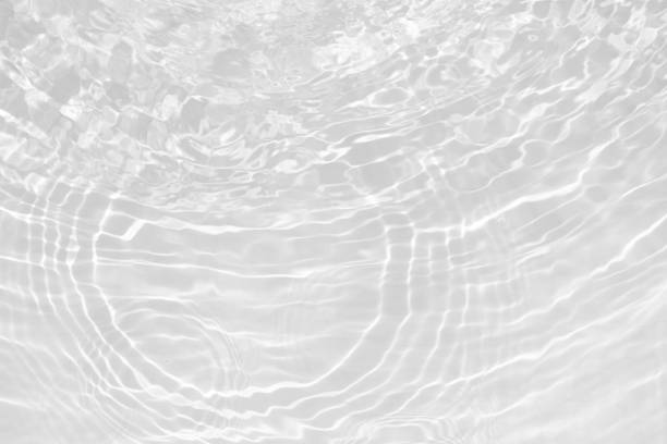 istock White water with ripples on the surface. Defocus blurred transparent white colored clear calm water surface texture with splashes and bubbles. Water waves with shining pattern texture background. 2151493914