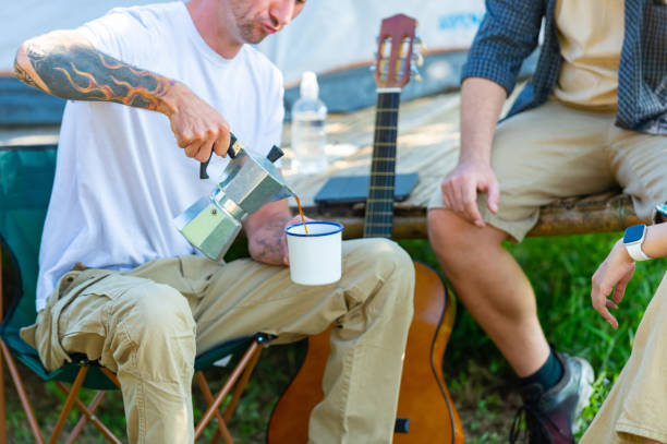 Group of Diversity people drinking coffee during camping together at forest mountain.