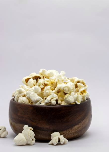 istock Popcorn in a Wooden Bowl Isolated on White Background with Copy Space in Vertical Orientation 2151507719