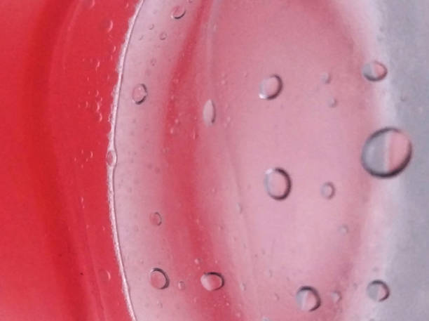 Close-up of soap bubbles floating on a water on a red background.