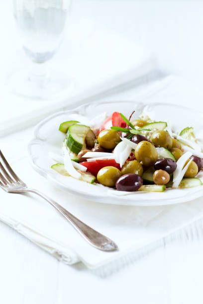Various olives on white wooden background. Close up. Copy space.