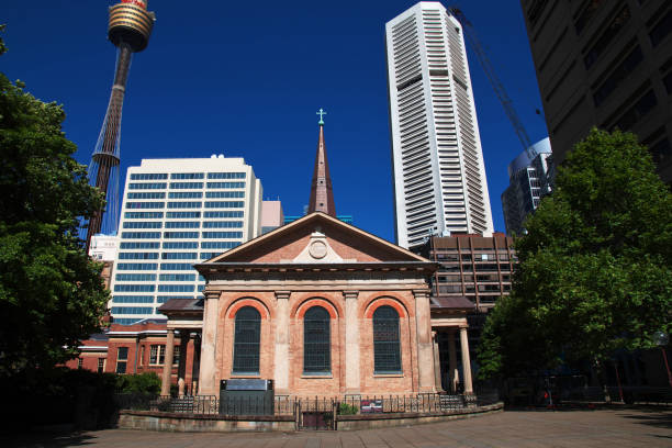St Marys Cathedral in Sydney, Australia, stands majestically under warm golden sunlight; The Gothic-style spires and dark surroundings create a dramatic and serene ambiance.