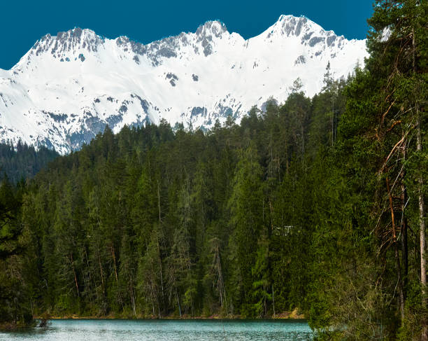istock Pristine alpine lake with snow-capped mountains in the austrian alps 2151515808