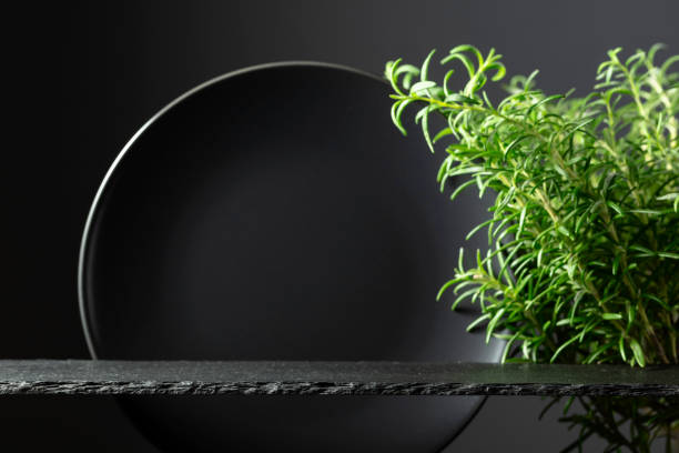 istock Black stone podium, black ceramic plate and branches of rosemary. 2151517150