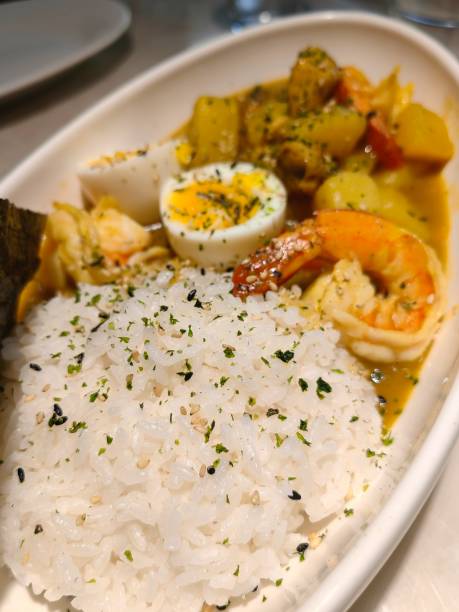 istock Shrimps in curry sauce and rice on a plate. horizontal view from above 2151517429
