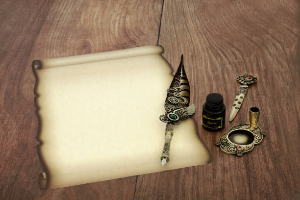 Antique desktop surface with old books, pen kit and blank parchment with quill pen in inkwell. Same series: