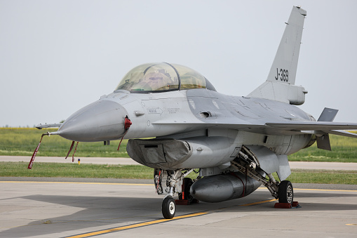 CALARASI, ROMANIA - APRIL 17, 2024: F16 Falcon fighter jet in parking position with red remove before flight ribbon attached.
