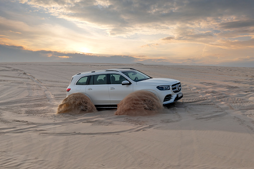 Doha, Qatar - May  02, 2024: Mercedes Benz GLS 580, 4Matic  4x4 vehicles bashing through the desert dunes in the evening sun