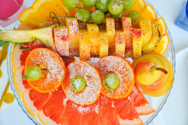 Fruit platter with powdered sugar for the banquet table. Assorted pears, grapes, oranges, pineapples and grapefruits.
