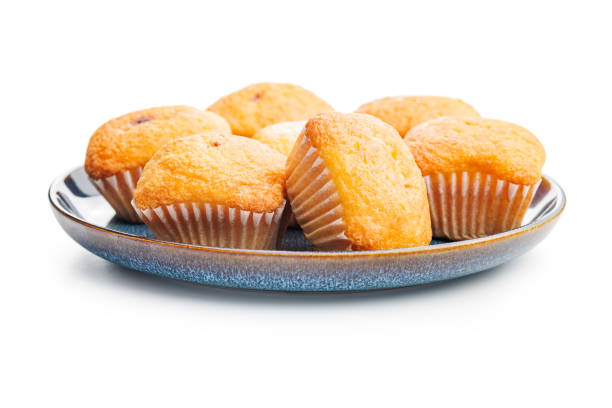 Magdalenas the typical spanish plain muffins on plate isolated on a white background.