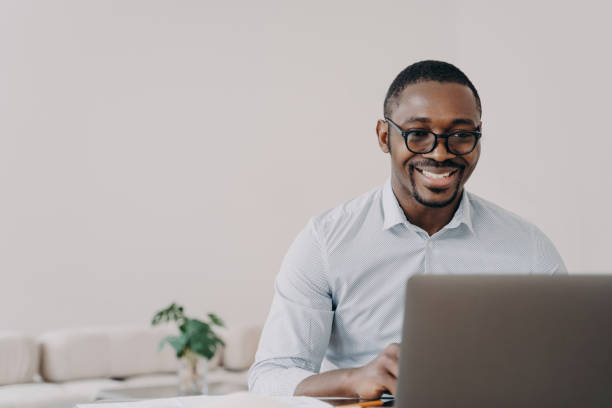 istock Cheerful businessman with laptop, enjoying his work in a light, modern setting. 2151526437