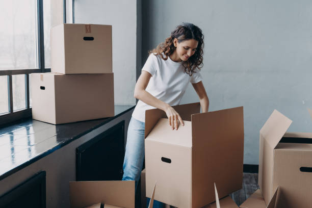 istock Person unpacking boxes, settling into a new home with a focused, organized approach. 2151526863