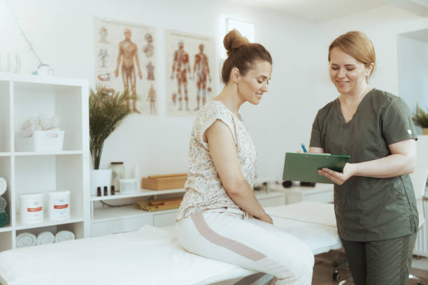 istock smiling therapist woman doing checkup and writing in clipboard 2151528689