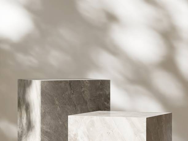 istock Two modern marble gray cuboid table podium in sunlight on beige white wall room 2151532370