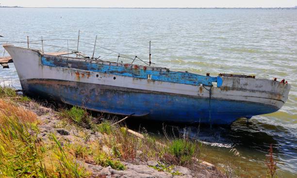 istock Broken boat shipwreck washed ashore after sea crossing 2151534293