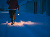 Asian Chinese mature woman tourist holding electric lamp exploring Grundarfjörður, Iceland Small Town in Winter