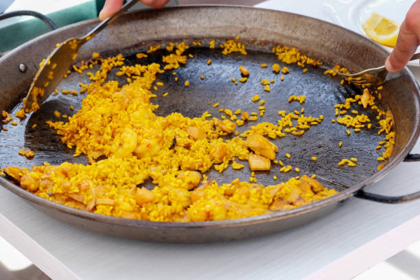 The waiter serves the Spanish national dish paella.