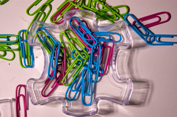 chaotic, office desk, colorful paper clips scattered across a white surface.