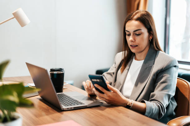 istock woman in the office using her smartphone 2151540559