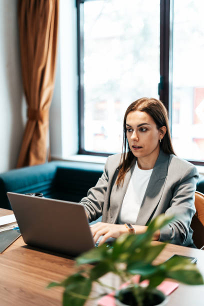 istock woman working in an office typing on the laptop 2151540568