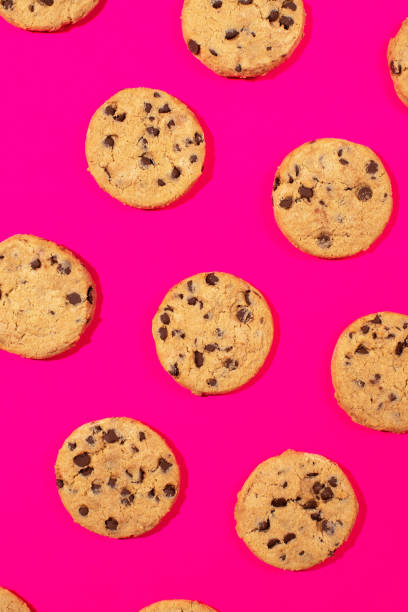istock Fresh cookies with chocolate chips on a pink background. Dessert, a pastry shop. Pattern. 2151547560