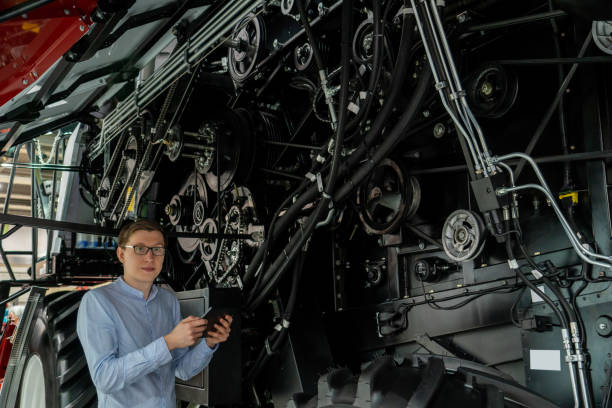 istock Serviceman with digital tablet on a next to combine harvester 2151550778