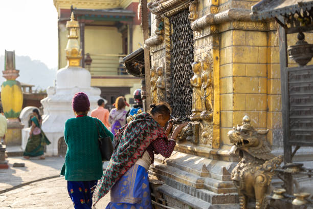 Kathmandu, Nepal-April 22,2024: Burning incense in temples is a common practice in many cultures, Lighting candles in temples symbolizes devotion and spiritual reverence, Prayer rolls are played while walking around the stupa in a clockwise direction