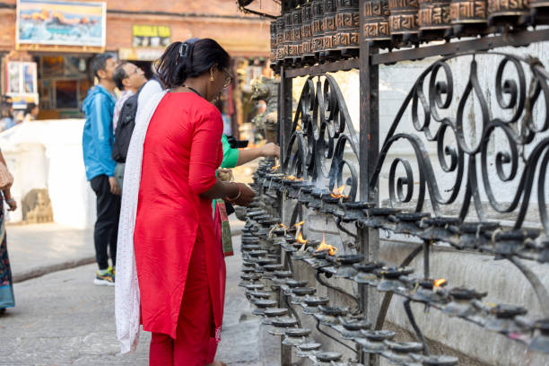 Kathmandu, Nepal-April 22,2024: Burning incense in temples is a common practice in many cultures, Lighting candles in temples symbolizes devotion and spiritual reverence, Prayer rolls are played while walking around the stupa in a clockwise direction