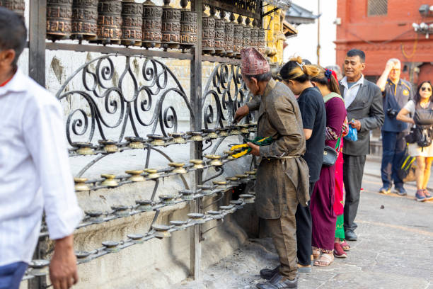 Rotating religious elements for touching turning spinning Buddhist prayer wheel at Buddhist monastery. Prayer wheels in Buddhist stupa temple. Buddhism religion concept