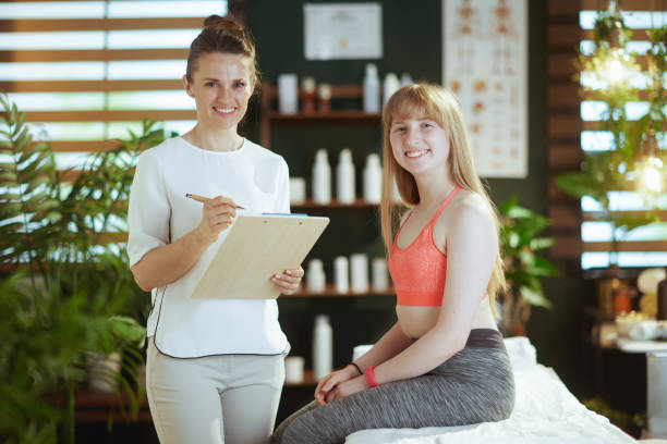 istock smiling female therapist in massage cabinet doing checkup 2151557545