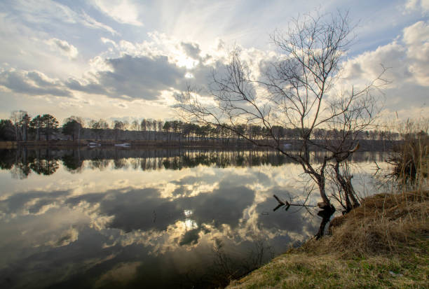 The reflection of the cloudy sky in the surface of the lake. The natural landscape.